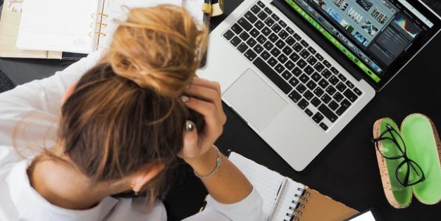 mulher desmotivada com trabalho e computador