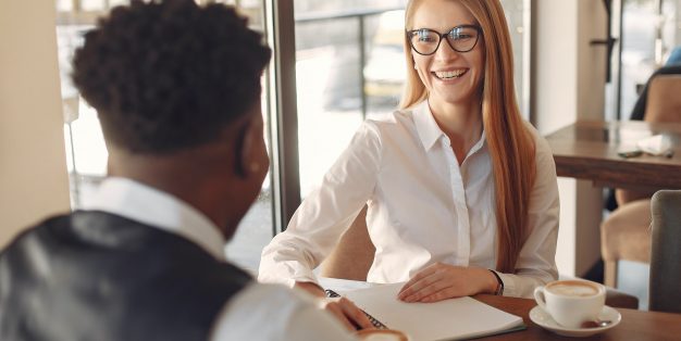 mulher a sorrir para homem em entrevista