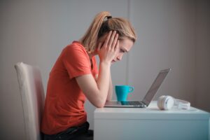 mulher afrente de computador desanimada