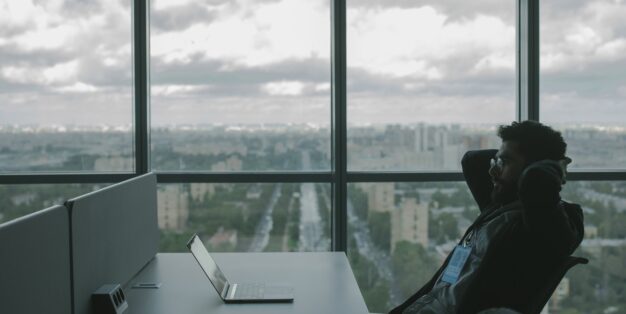 homem no trabalho com computador e postura reclinada