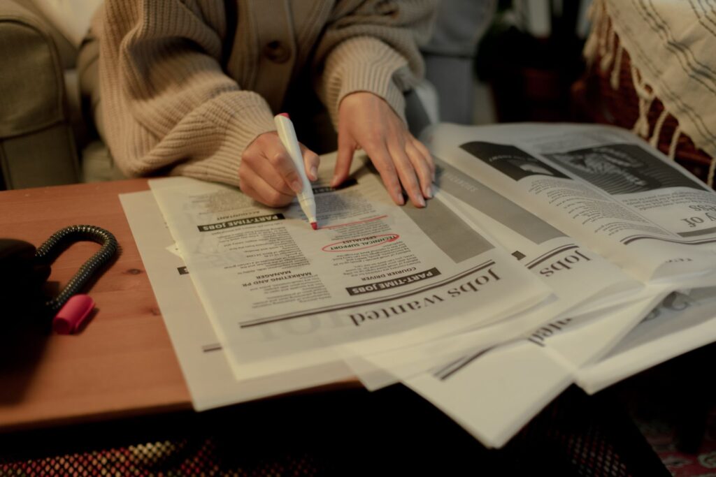 Mulher a procurar emprego nos classificados do jornal